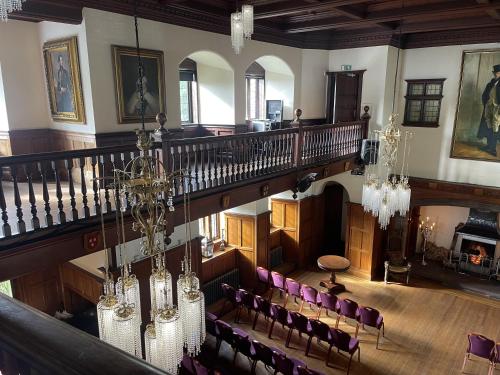 an overhead view of a room with a staircase and chairs at Dalston Hall in Carlisle
