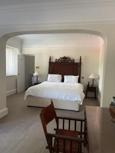 a bedroom with a large white bed and a table at Dalston Hall in Carlisle