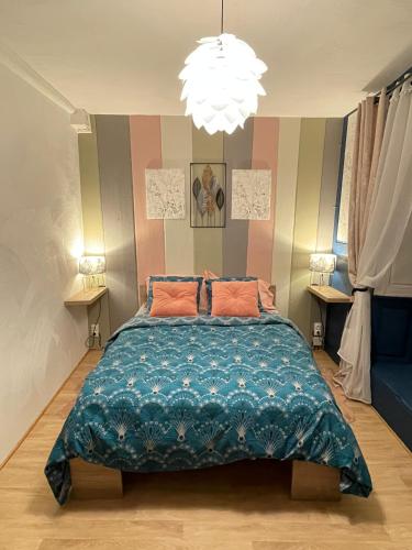 une chambre avec un grand lit et un lustre dans l'établissement Gîte À l'aigle de sable, à Kintzheim