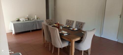 een eettafel met stoelen en een tafel met eten erop bij Nqabanqaba in Richards Bay