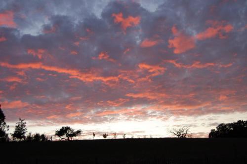 a sunset in a field with a cloudy sky at Clos de l'Arthonnet in Flavignac