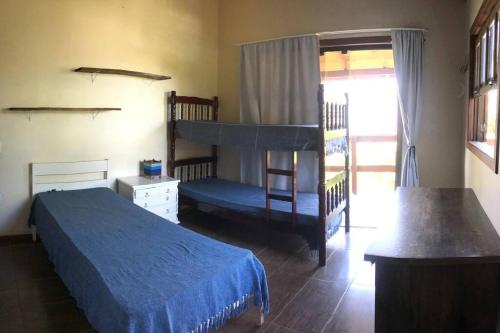 1 dormitorio con 2 literas y ventana en Nova Casa Laranjeiras, en Garopaba