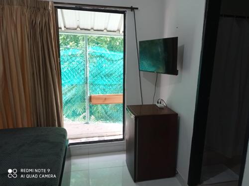 a living room with a window and a television at Posada Miss Mazie in San Andrés