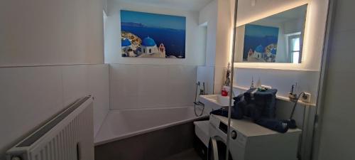 a bathroom with a sink and a mirror at Lake FeWo Santorini in Oberteuringen