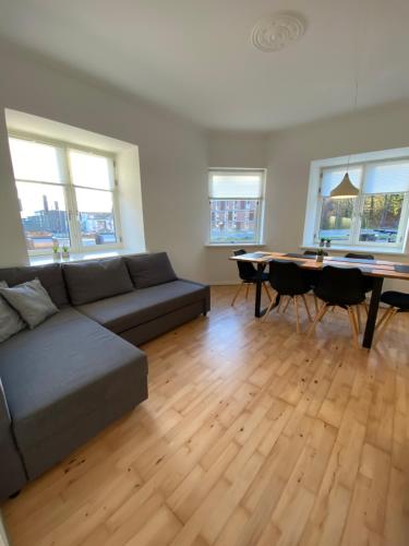uma sala de estar com um sofá e uma mesa em Central Ground Floor Apartment with Parking em Aarhus