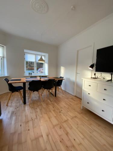 sala de estar con mesa, sillas y TV en Central Ground Floor Apartment with Parking en Aarhus