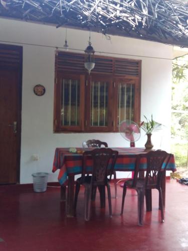 a dining room table and chairs in a room at Yunal's Place in Matara