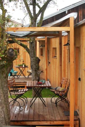 een houten terras met een tafel en stoelen en een boom bij Tinyhaus auf dem Schacherbauerhof in Mehring