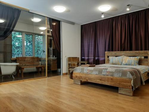 a bedroom with a bed and a tub and a bath room at Champêtre Park View Apartments in Rīga