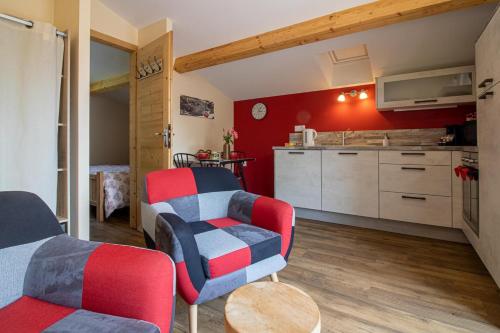 Il comprend un salon avec deux chaises et une cuisine. dans l'établissement Le Nidouyé appartement 2 adultes UNIQUEMENT à Saint Lary Soulan, à Saint-Lary-Soulan