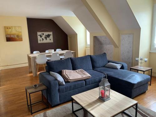 sala de estar con sofá azul y mesa en Nevers, appartement de standing proche de la gare, en Nevers