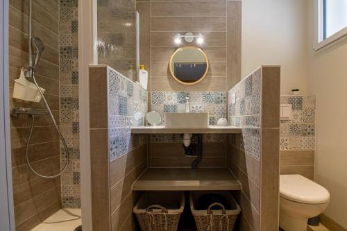 une salle de bain avec un lavabo, des toilettes et un miroir dans l'établissement Le Nidouyé appartement 2 adultes UNIQUEMENT à Saint Lary Soulan, à Saint-Lary-Soulan