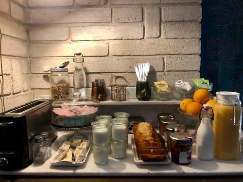una encimera de cocina con comida y otros artículos. en Reglisse et Pain d'Epices - Chambres d'hôtes, en Honfleur