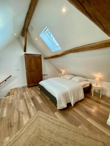 - une chambre mansardée avec un lit et une lucarne dans l'établissement Maison calme et chaleureuse à la campagne, à Pont-sur-Seine