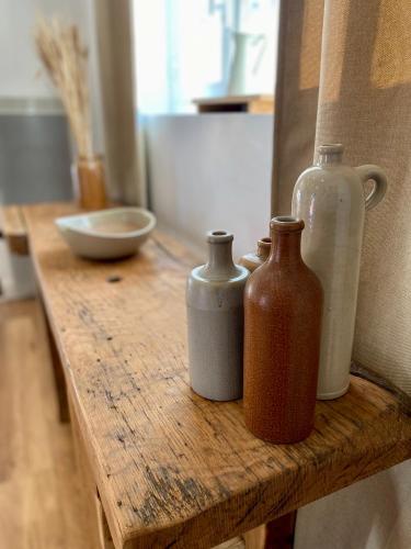 une table en bois avec trois bouteilles au-dessus dans l'établissement Maison calme et chaleureuse à la campagne, à Pont-sur-Seine