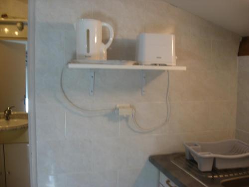 una cocina con 2 electrodomésticos blancos en la pared en T 2 avec velux au 1er étage de 34 m2, en La Londe-les-Maures
