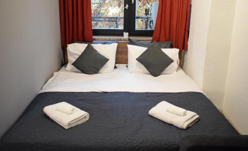 een slaapkamer met een bed met twee handdoeken erop bij M - Square Private Rooms in Skopje