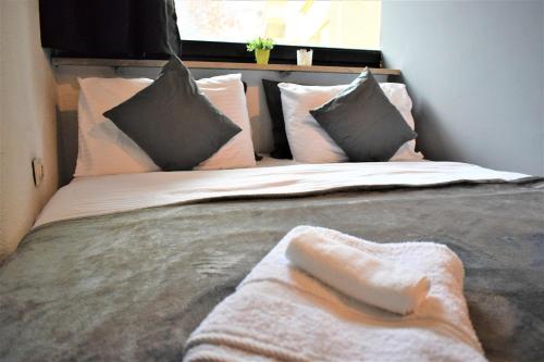 a bed with white sheets and pillows on it at M - Square Private Rooms in Skopje
