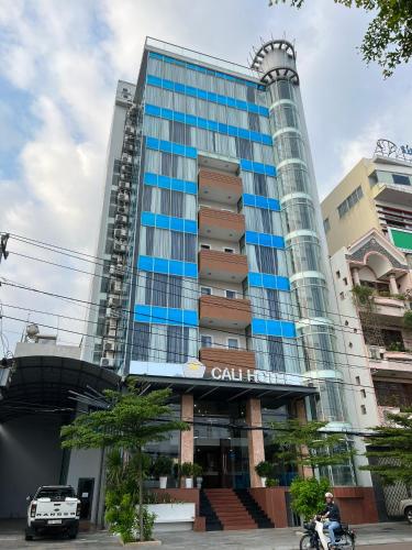 a tall building with a man on a motorcycle in front of it at Cali Hotel Quy Nhơn in Quy Nhon