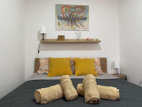 ein Bett mit vier braunen Kissen und einem Regal an der Wand in der Unterkunft Apartman Kosta in Leskovac