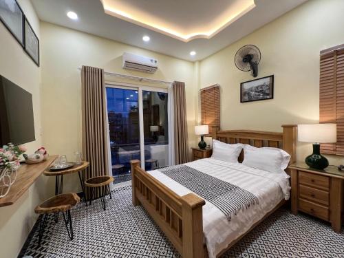 a bedroom with a bed and a desk and a window at Anam Homestay in Ho Chi Minh City