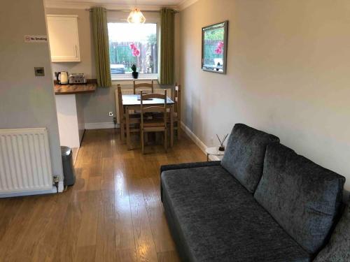 een woonkamer met een bank en een tafel bij Dunfermline Home with Free Parking Near Amazon & M90 in Dunfermline