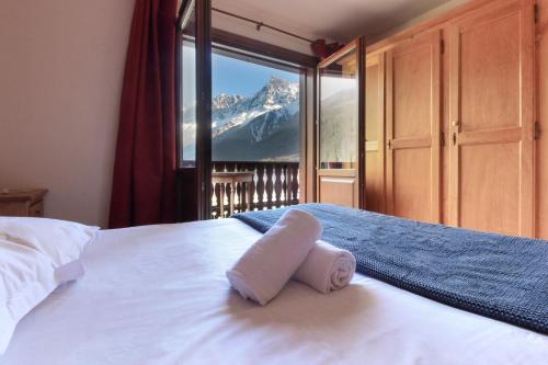 1 cama con toalla y vistas a la montaña en Les Grands Balcons - Newly Renovated - Rock Climbing, Trails, TMB near, en Les Houches