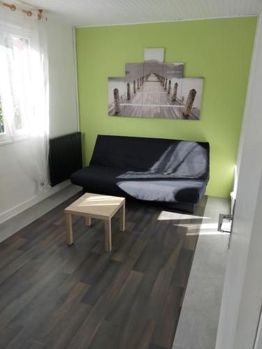 ein Wohnzimmer mit einem Sofa und einem Tisch in der Unterkunft Guern ,maison à la campagne in Guern