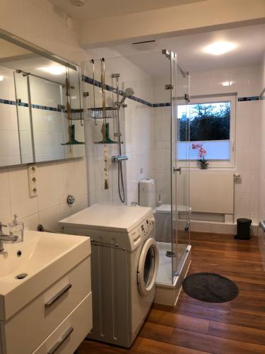 ein Bad mit einer Waschmaschine und einer Dusche in der Unterkunft Ferienwohnung Oberdeck in Fehmarn