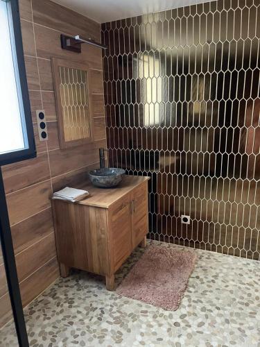 un bagno con lavandino e una parete con piastrelle di Chambre avec entrée privée a Saint-Renan
