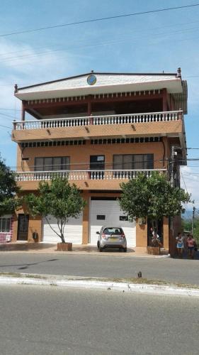 a building with a car parked in front of it at Casa Raices in La Dorada
