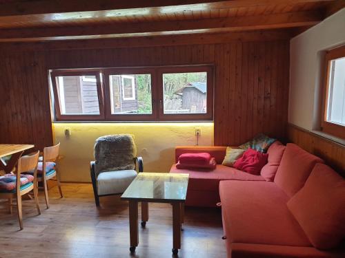 a living room with a red couch and a table at horská chata Cecilie in Olešnice v Orlických horách