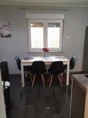 mesa de comedor con 4 sillas y ventana en Apartment Amalia, en Varaždin