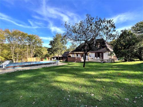 a house with a large yard with a tree at Chez Pascaline in Sarliac-sur-lʼIsle
