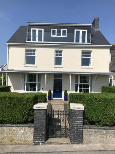 une maison blanche avec une porte noire dans l'établissement Woodlands, à Southerndown