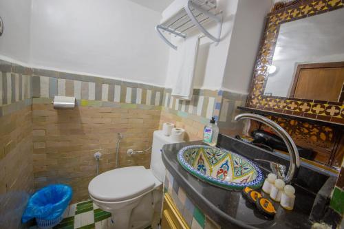 uma casa de banho com um lavatório, um WC e um espelho. em Riad Fes Elite em Fez