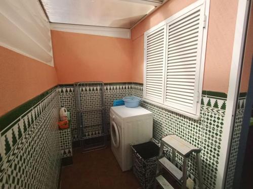 uma pequena casa de banho com um WC e uma janela em Adosado playa Islantilla campo de golf em Huelva