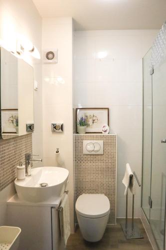 a white bathroom with a toilet and a sink at Josipa in Zagreb