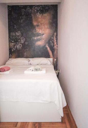 a white bed with a painting on the wall at Josipa in Zagreb