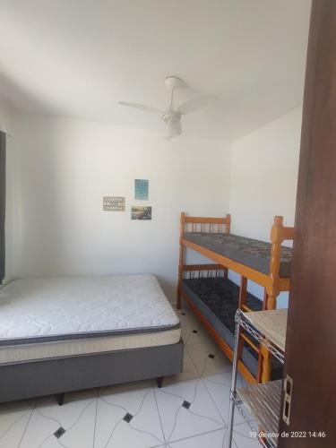 a bedroom with two beds and a ceiling fan at Casa Arejada 300mts do mar in Guaratuba
