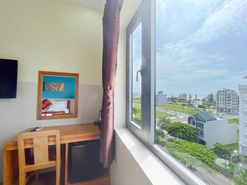 a window with a desk and a view of the ocean at Sea Star Hotel in Phan Thiet