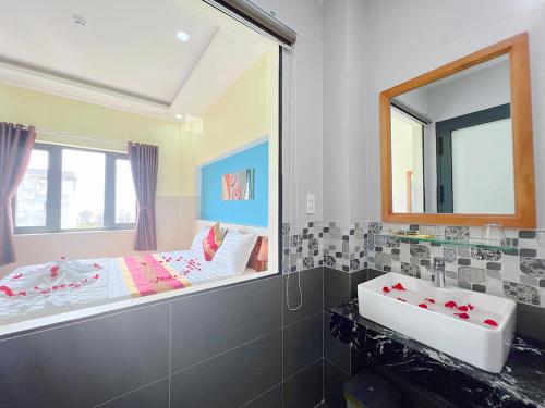 a bathroom with a large mirror and a sink at Sea Star Hotel in Phan Thiet