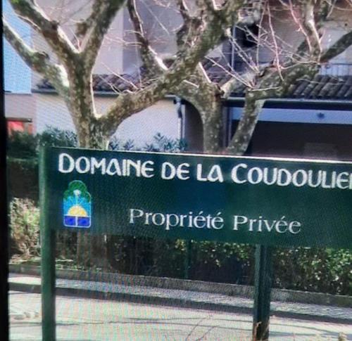 a green street sign in front of a building at Domaine de la coudoulière in Six-Fours-les-Plages
