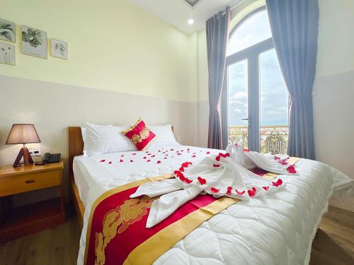 a bedroom with a bed with white sheets and a window at Sea Star Hotel in Phan Thiet