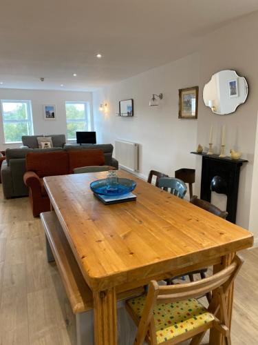 a dining room and living room with a wooden table at Island town Apartment in Enniskillen