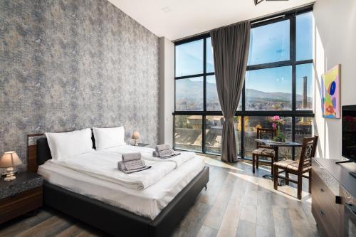 a bedroom with a bed and a large window at Art Magus Hotel in Sofia