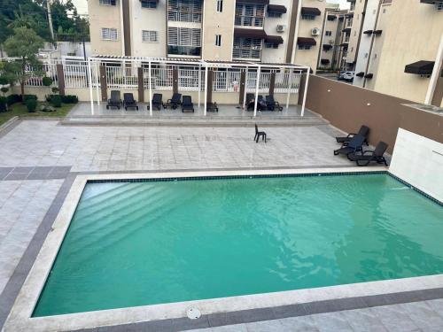 a dog is standing next to a swimming pool at Apartamento Esme in Santo Domingo