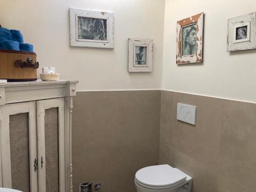 a bathroom with a toilet and pictures on the wall at BLQ 01boutique B&B in Bologna
