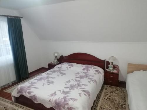 a bedroom with a bed with a white and purple blanket at Casa Daiana in Borsa