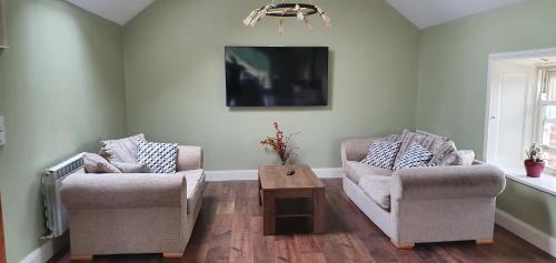 a living room with two chairs and a table at The Haggard Self Catering Accommodation in Castleblayney